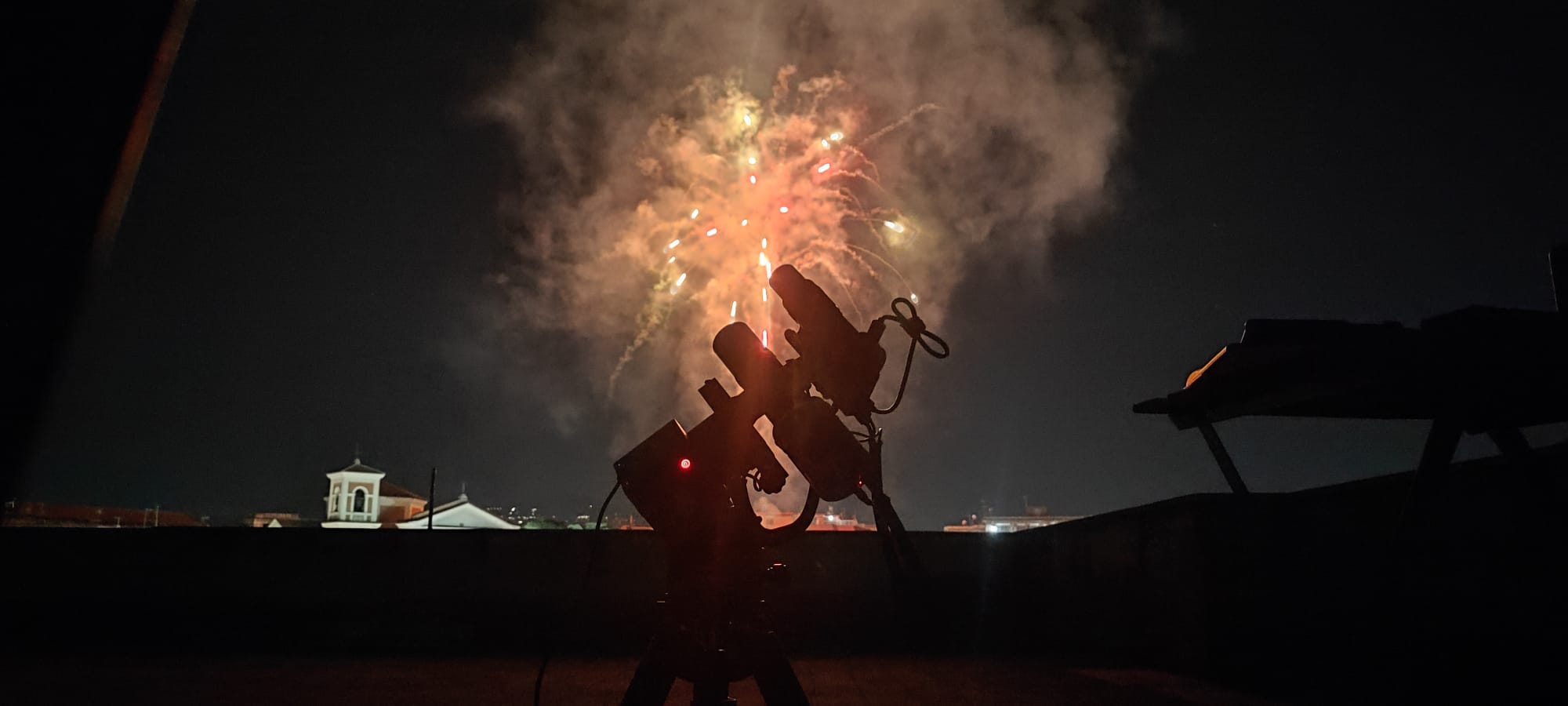 Setup astronomico in silhouette davanti ai fuochi d'artificio