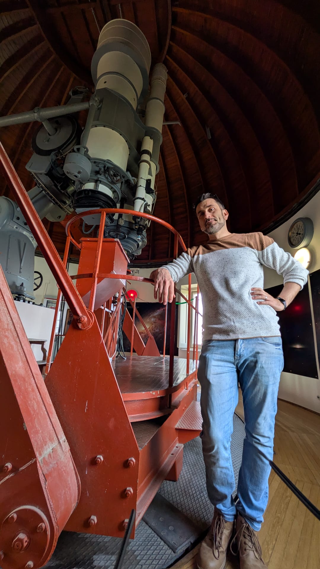 Alessio Scudieri accanto a un grande telescopio in osservatorio